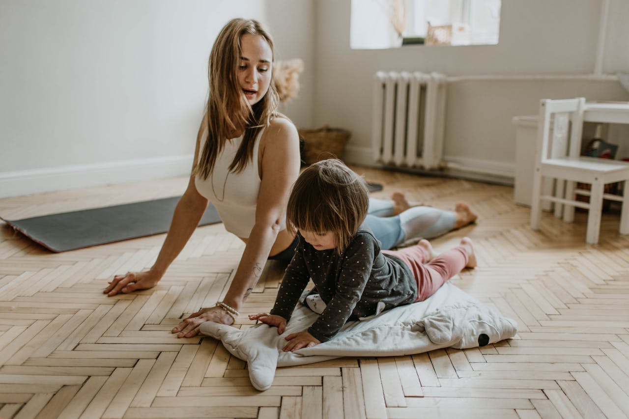 hero-img A mother and child practicing yoga together at home on a sunny day, fostering wellness and connection.